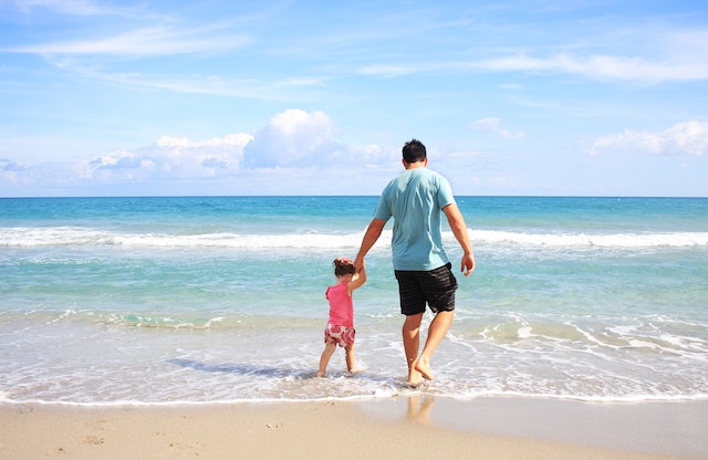 imagemde paie filha andando pela praia